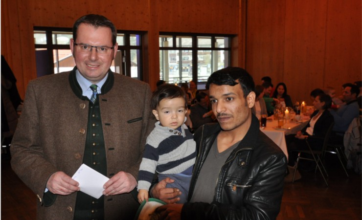 Christian Köck übergab den Eltern und ihrem Nachwuchs Lätzchen im Rottach-Stil und eine CD nach Wahl - bayerische Musik oder Schlaflieder. Auch die syrische Familie Almohammad (im Bild: Vater Fadlullah und Sohn Oday) sagte Danke. 
